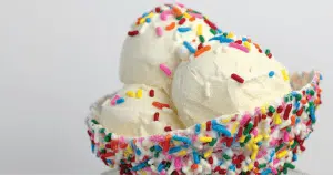 A bowl of vanilla ice cream with multicolor sprinkles.