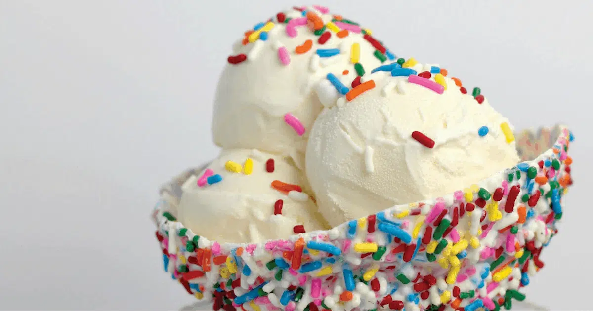 A bowl of vanilla ice cream with multicolor sprinkles.
