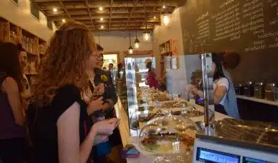 A woman stands in a line at a chocolate shop while on an Off the Beaten Path Food Tour. 
