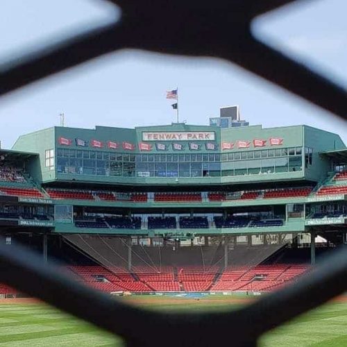 Fenway Park in Boston as seen through a chainlink fence.