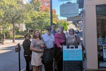 A group of people stand outside Gormely's Cafe in Lowell, MA. 